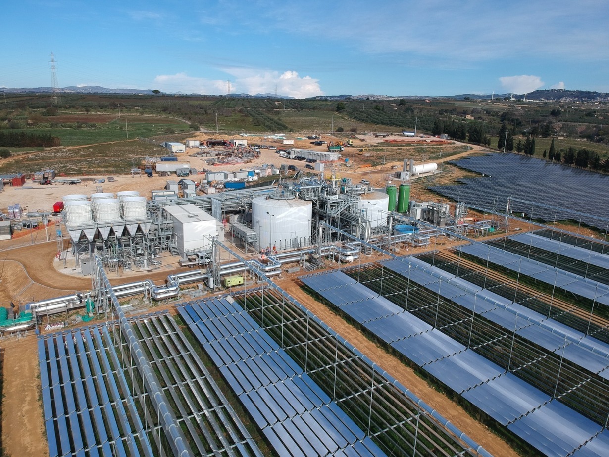 Industrielle Solaranlage mit Feldern und Gebäuden auf freiem Gelände.