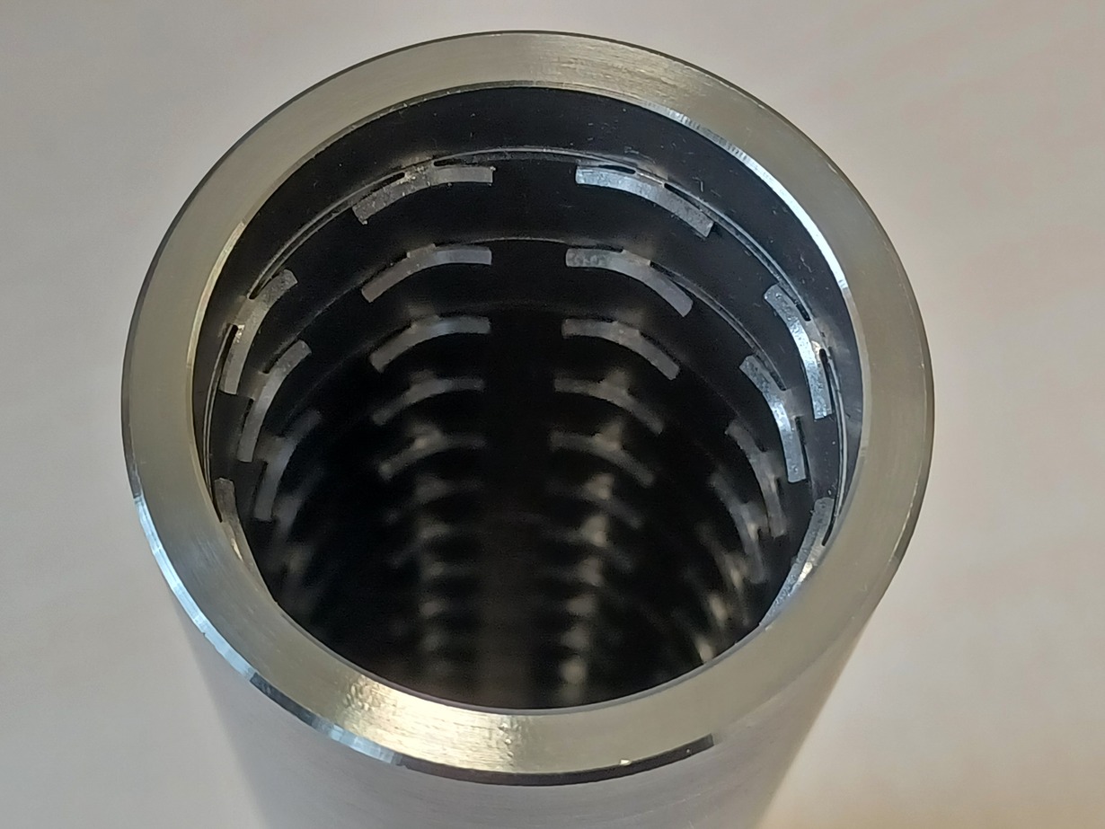 Metallzylinder mit gerillter Innenstruktur aus der Nähe fotografiert.