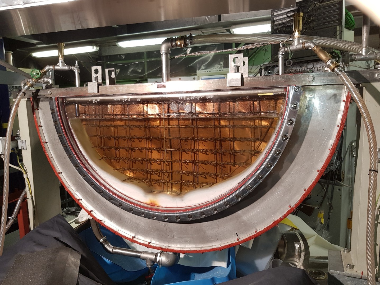 Experimentelle Vorrichtung im Labor mit mehreren Schläuchen und metallischen Komponenten.